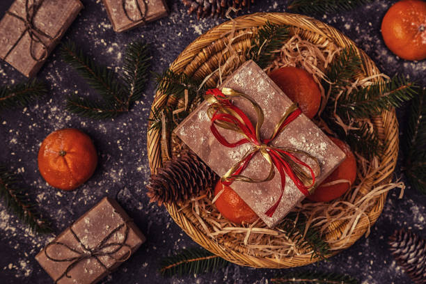istock Christmas composition with tangerines, gift boxes, cones on a dark wooden background. 863441928