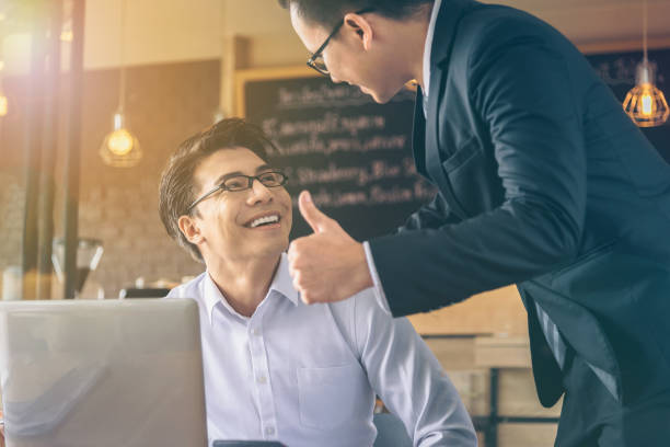 Businessman was given a thumbs-up and compliments from his boss who successfully worked. stock photo
