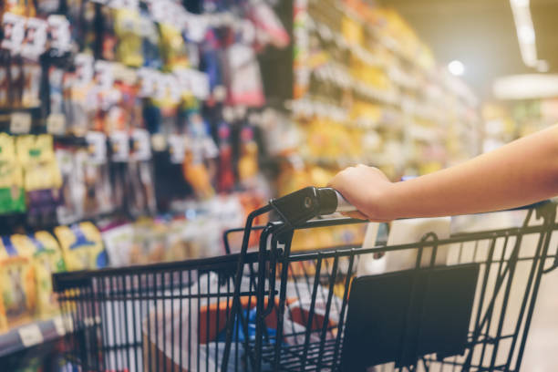 istock Asian woman's hand with supermarket, trolley and many objects that are blurred background. 863445580