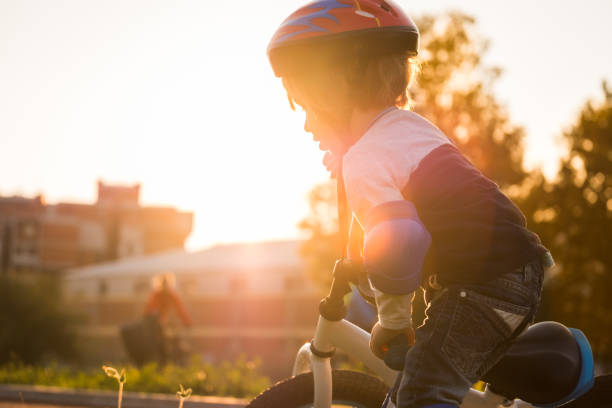 istock Little boy on sunset with bicycle 863453582