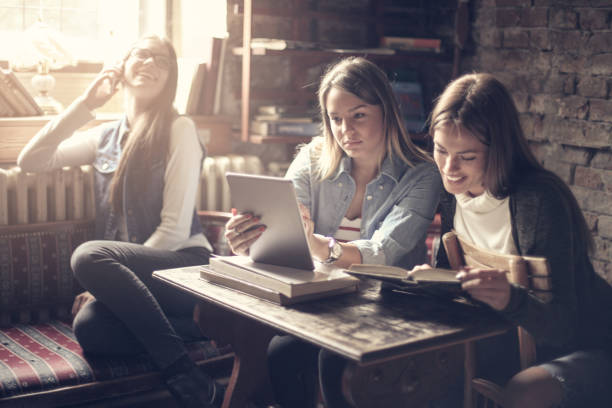 istock Happy smiling girls in library sitting together and studying. 863453908