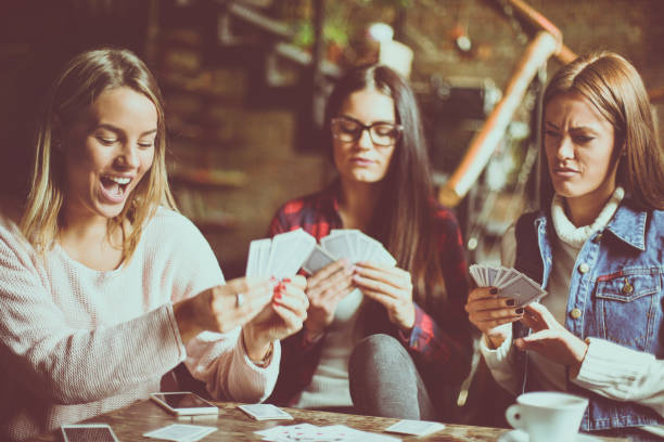 istock Three girls at home playing cards. 863466850