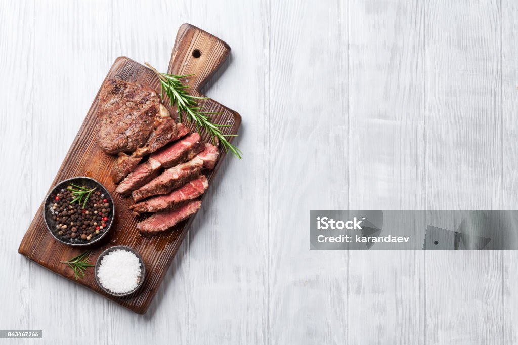 Steak de bœuf grillé aux épices sur une planche à découper - Photo de Bifteck libre de droits