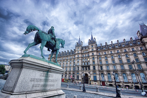 A wide angle view of Lime Street and North Western Hall, Liverpool. In the foreground is a statue of Prince Albert, the Prince Consort on horseback.
