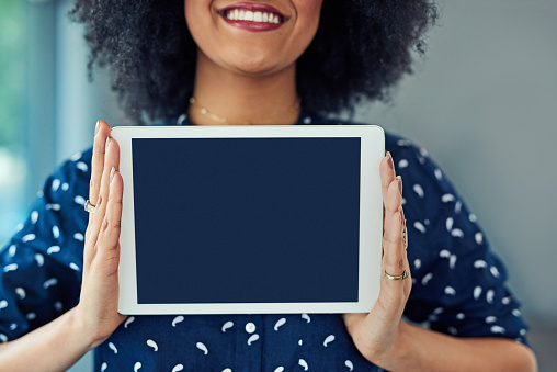 Cropped shot of a young woman holding up a digital tablet with a blank screen