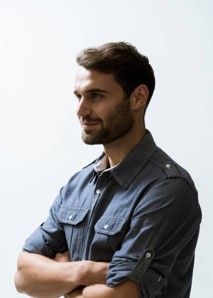 istock Smiling businessman with arms crossed against wall 863476614