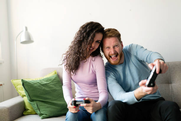 istock Happy couple playing video games at home 863481614