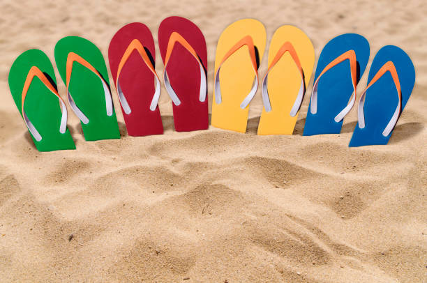 istock Man lifestyle four relax flip flops on orange beach sand 863481696