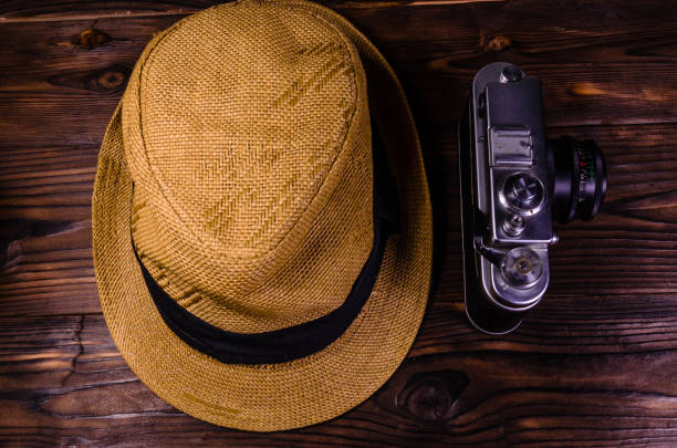 istock Old rangefinder camera and hat on a wooden table. Top view 863482612