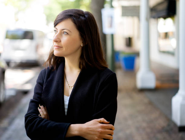 istock Thoughtful professional with arms crossed in city 863489236