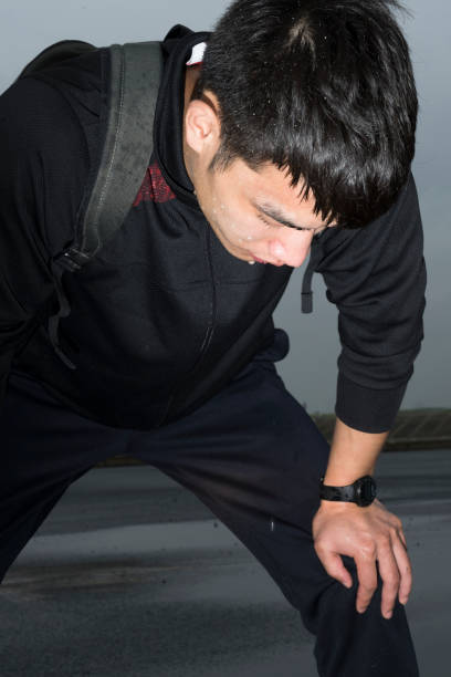 istock young asian athlete resting with sweat pouring after exercising 863492220