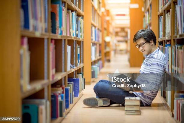 Foto de Livro De Leitura Do Jovem Asiático Universidade Estudante Na Biblioteca e mais fotos de stock de Asiático e indiano