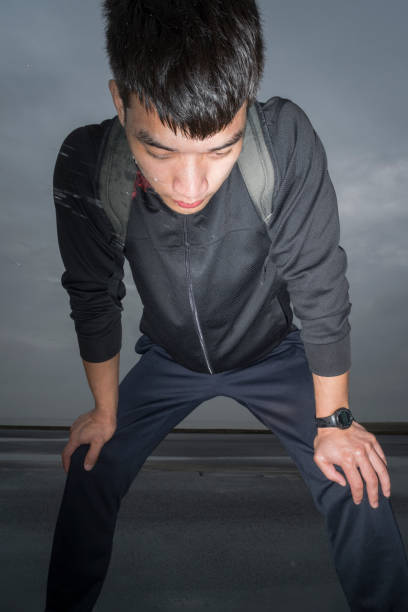 istock young asian athlete resting with sweat pouring after exercising 863492426