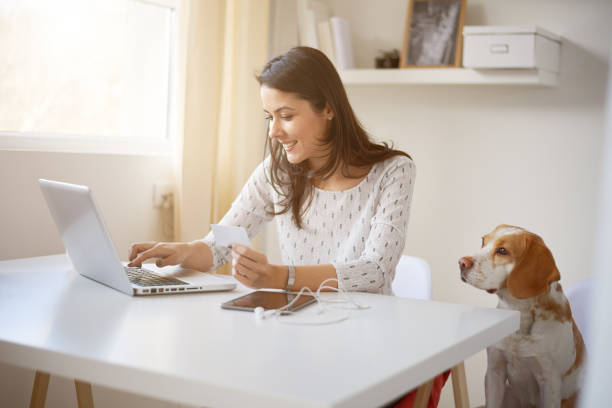 молодая кавказская предпринимательница делает на линии оплаты - credit card women laptop electronic banking стоковые фото и изображения