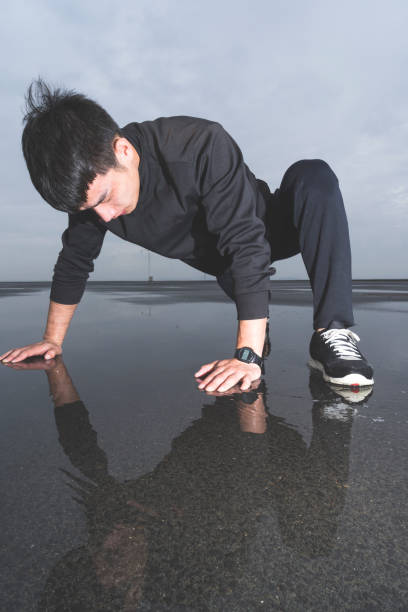 istock young athlete doing push-ups in puddle after rain 863492660