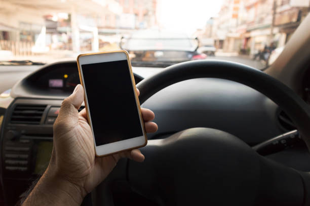 istock man driving a car holding the smart phone 863497436