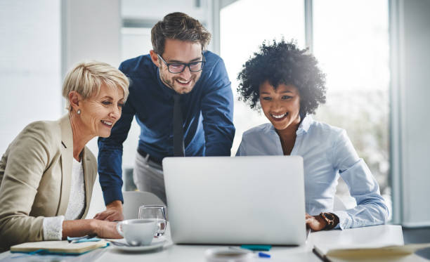 It's impossible until we show you that it's possible Shot of a group of businesspeople working together on a laptop white collar worker stock pictures, royalty-free photos & images