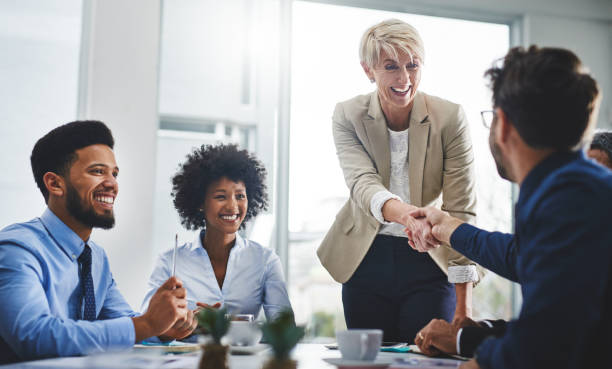 You'll love the togetherness of our team Shot of two businesspeople shaking hands in a meeting employee introduction stock pictures, royalty-free photos & images