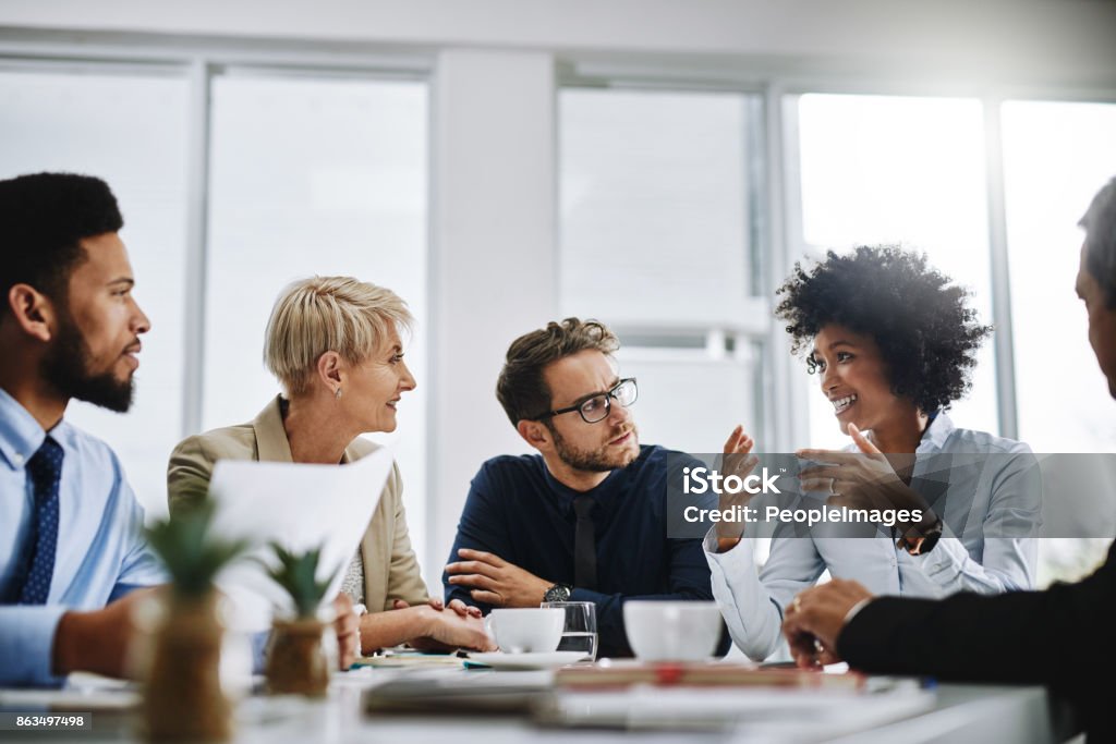 I need everyone to give me their best ideas Shot of a group of businesspeople sitting together in a meeting Teamwork Stock Photo