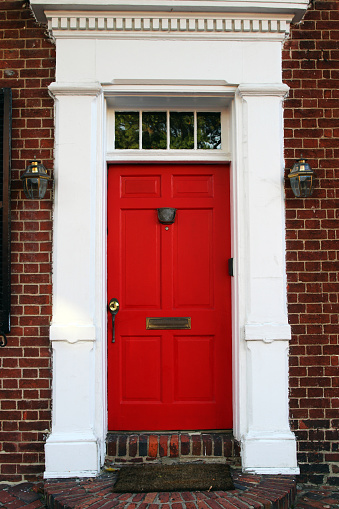 A red front door of a Colonial style house.