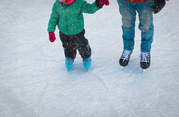 istock father and little daughter learning to skate in winter 863498338