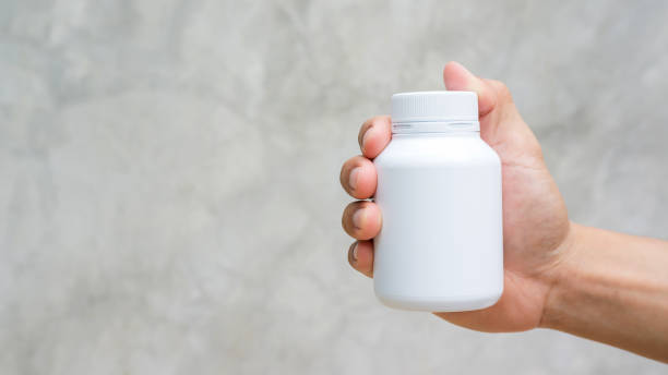 istock Man holding a white medicine bowl on gray background. 863501762