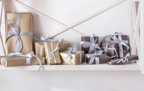 istock Elegant presents, gift boxes on white shelves at wall background 863512030