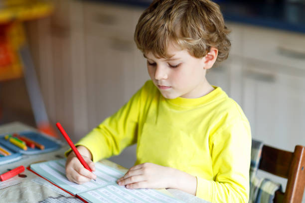 istock Happy school kid boy at home making homework 863512466