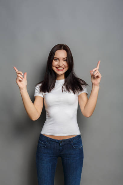 istock Excited woman shows something, point finger up 863517250