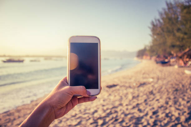 Women photographing beach scenery