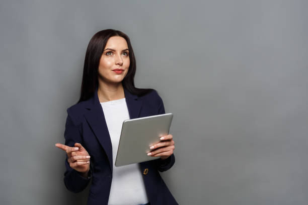 istock Woman with tablet on gray background 863517508