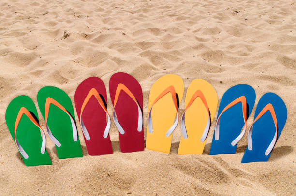 istock Man lifestyle four relax flip flops on orange beach sand 863520050