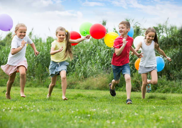 istock children running with air balloons in park 863521680