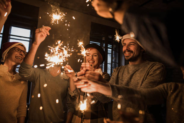 istock Young happy friends having fun on Christmas party while using sparklers. 863523992