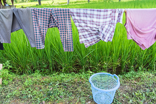 Wooden clothes line for dry clothes in the sun in paddy field.Thailand