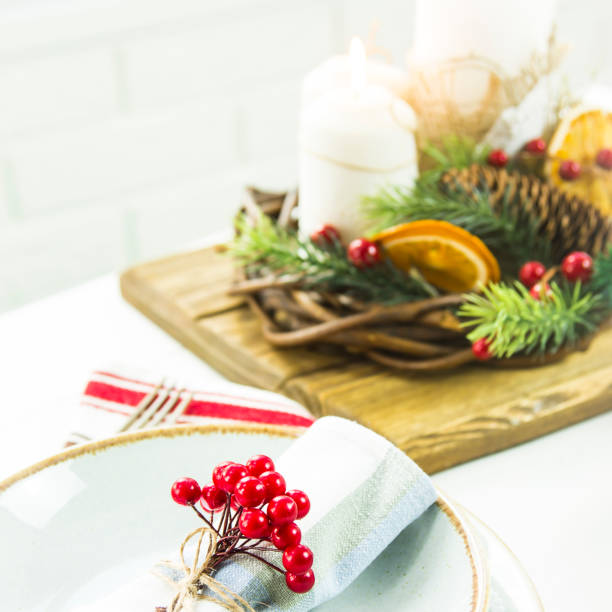 istock a table setting for Christmas with a viburnum on a plate and an ornament from a Christmas wreath with candles 863529220