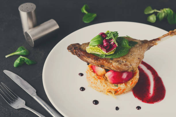 istock Restaurant meals. Duck confit with vegetables on black backgroun 863531722