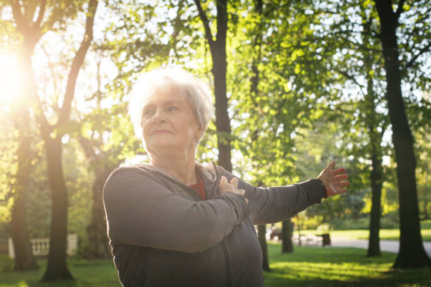 istock Senior woman stretching hand and exercising in park alone. 863541850