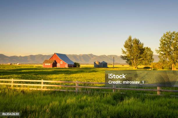 Summer Sunset With A Red Barn In Rural Montana And Rocky Mountains Stock Photo - Download Image Now