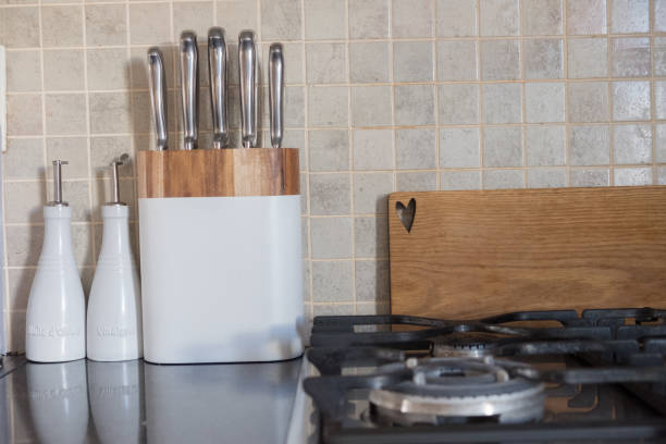 istock Set of chef knives on kitchen counter next to chopping board and stove. 863549366