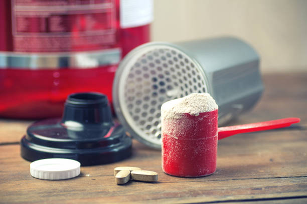 scoop of protein powder necessary nutrition for muscle recovery after an intensive workout stock photo