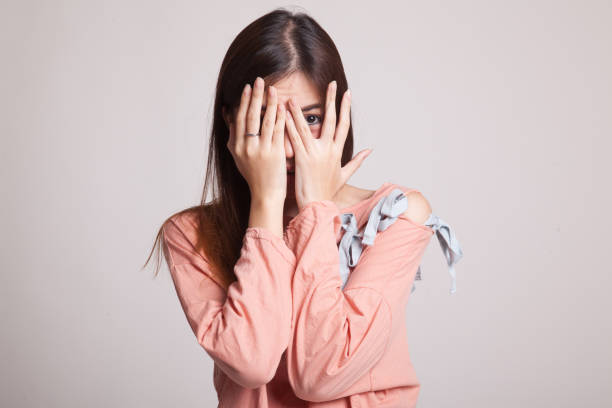 istock Beautiful young Asian woman peeking through fingers. 863553066