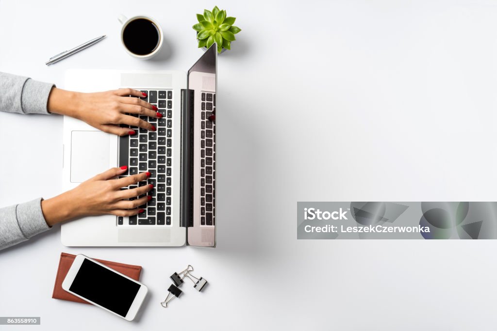 Female hands working on modern laptop. Office desktop on white background Desk Stock Photo