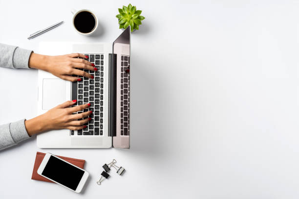 Female hands working on modern laptop. Office desktop on white background stock photo