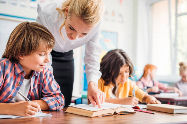 istock teacher helping schoolboy with exercise 863559728