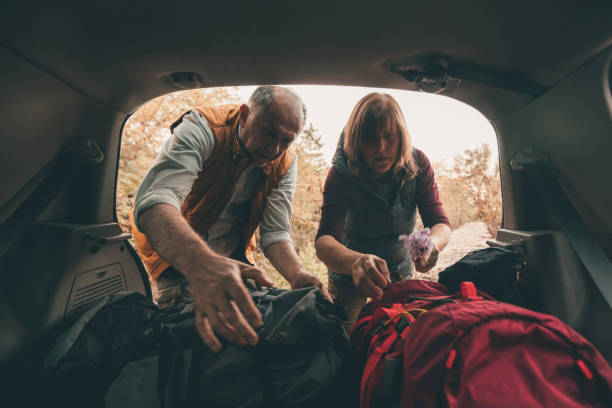 istock Senior Couple pack backpacks in car 863564670