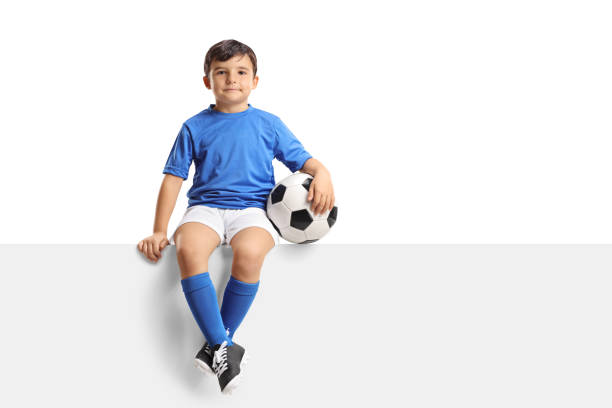 little footballer sitting on a panel - ball horizontal outdoors childhood imagens e fotografias de stock