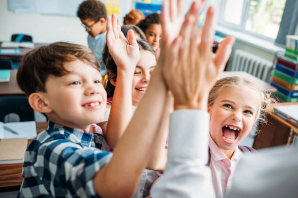 istock kids giving high five to teacher 863565092
