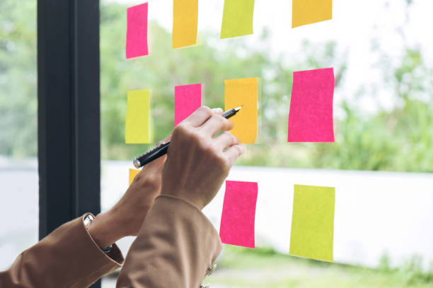 istock Young creative professional leader using notes in glass wall to writing strategy business plan, management and people concept 863565152