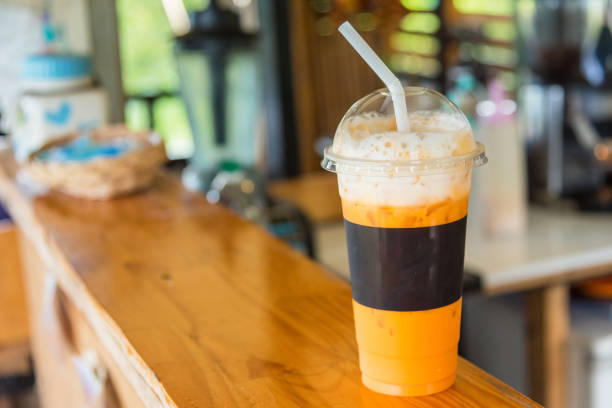 istock The sweet cooled thai tea drink with ice on shop counter background. 863565896